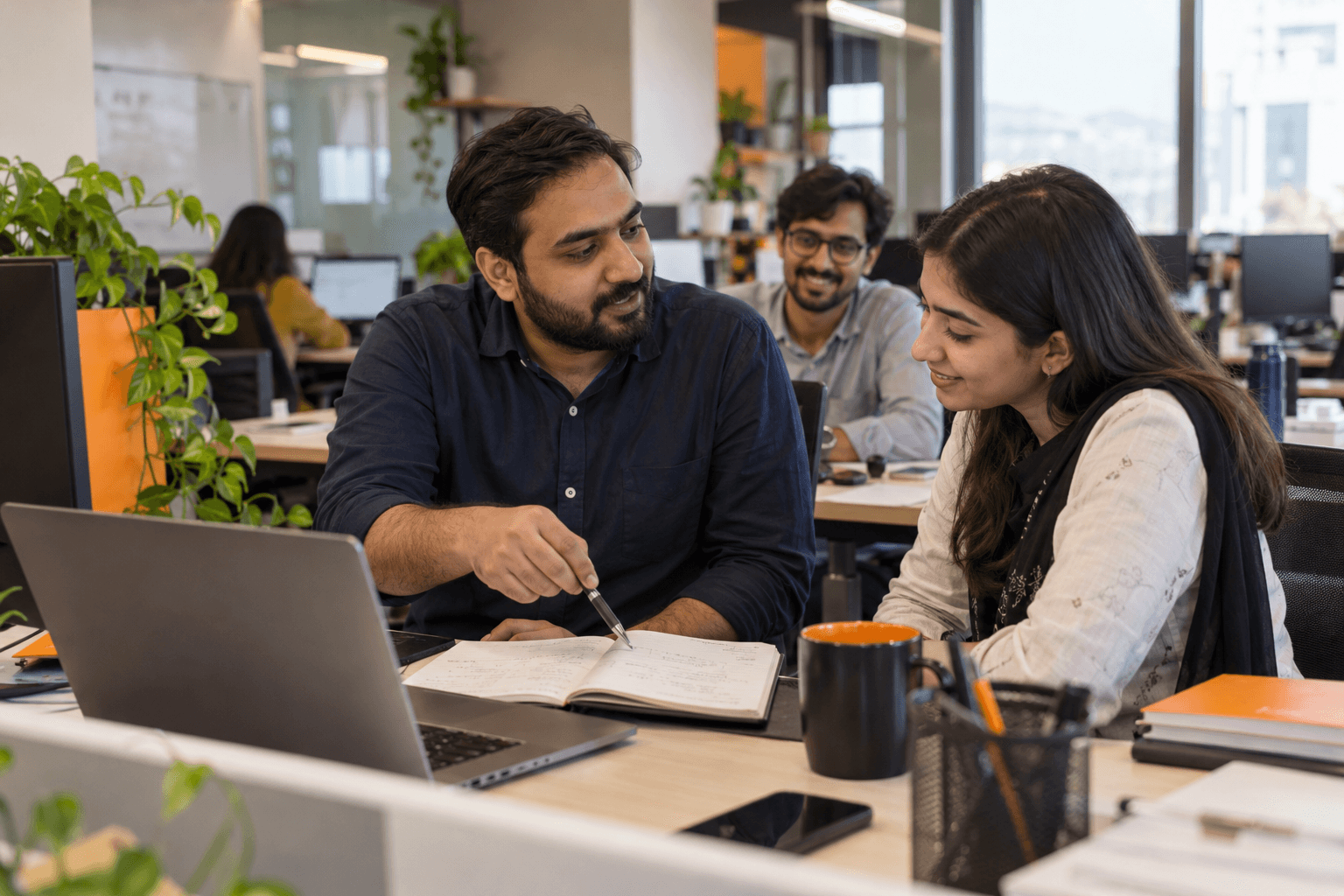 BaliTech employees collaborating and mentoring at their desk
